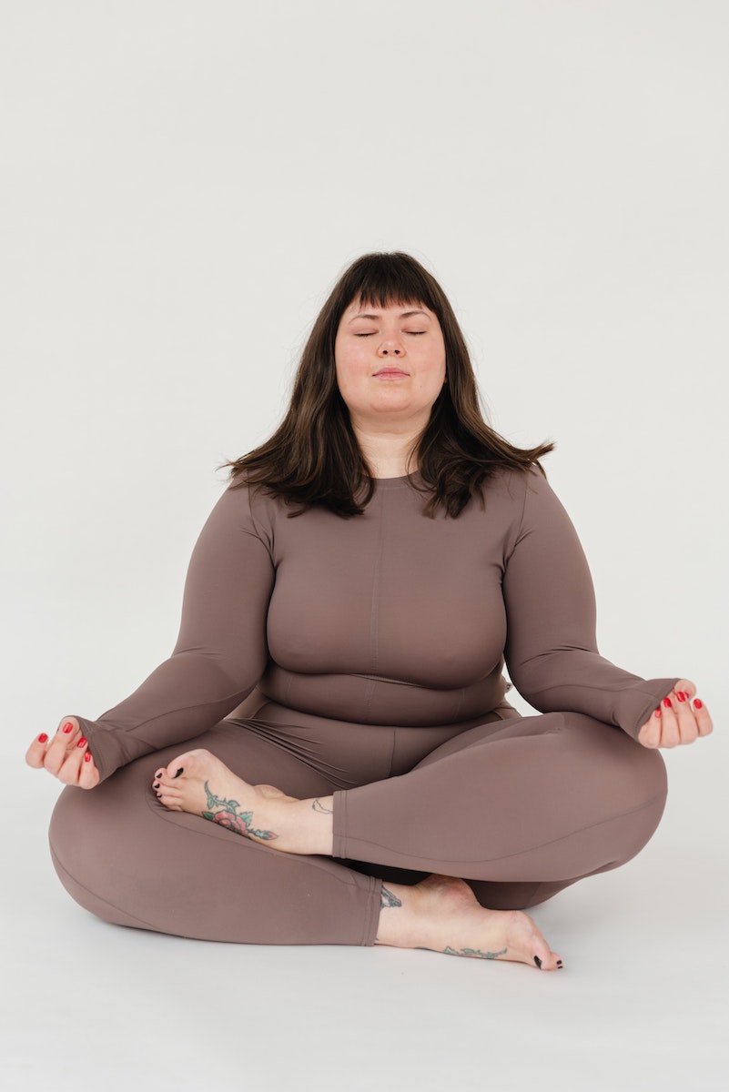 Serene plus size female meditating in Lotus pose